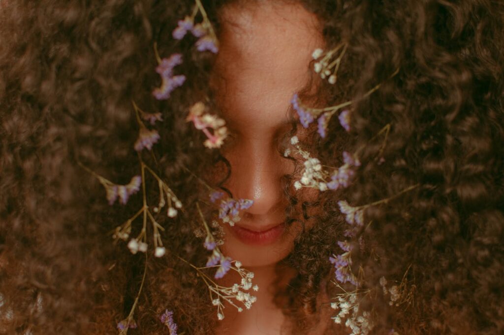 a woman with flowers in her curly hair